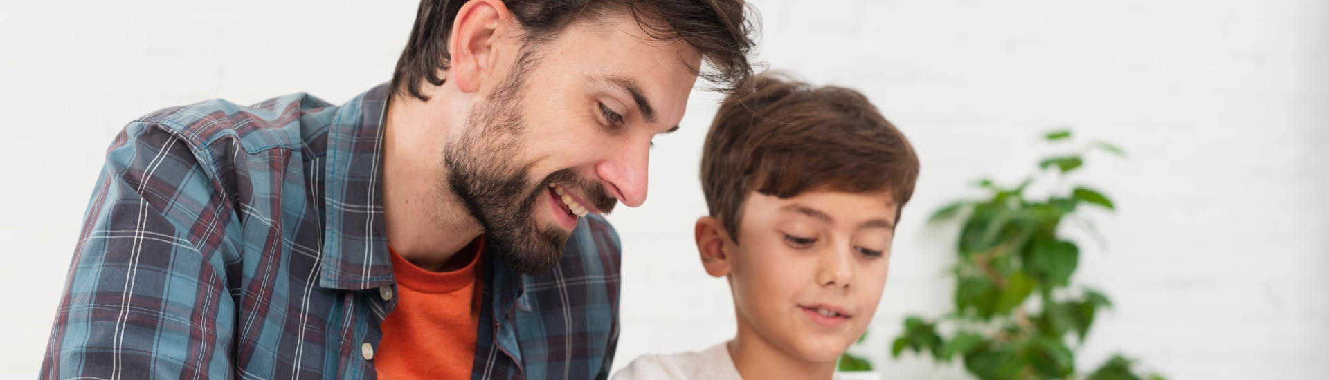 father helping little son with homework